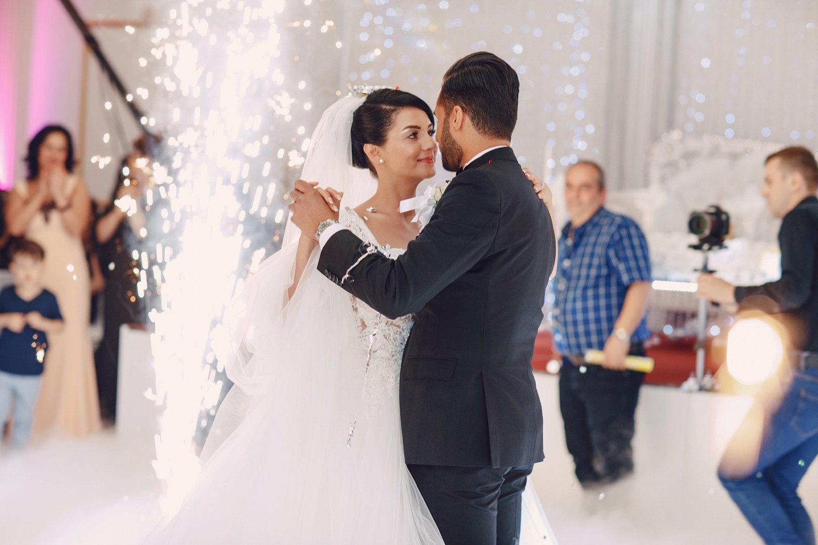 Newlyweds celebrating beside cold-spark effects at their reception