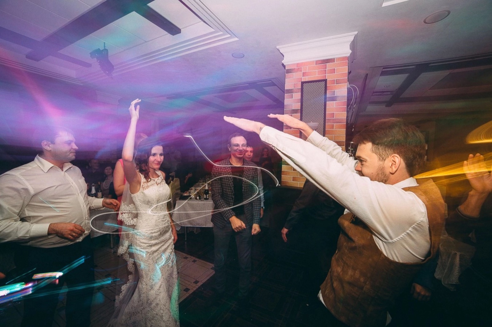 Bride and groom celebrating with guests on a wedding dance floor